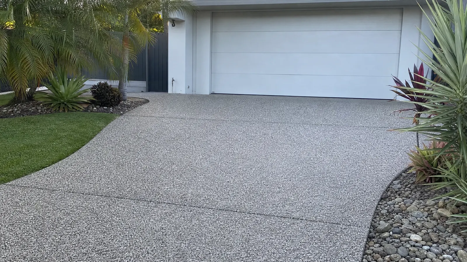 Before and after cleaning of stained exposed aggregate concrete showing dramatic improvement after professional cleaning treatment