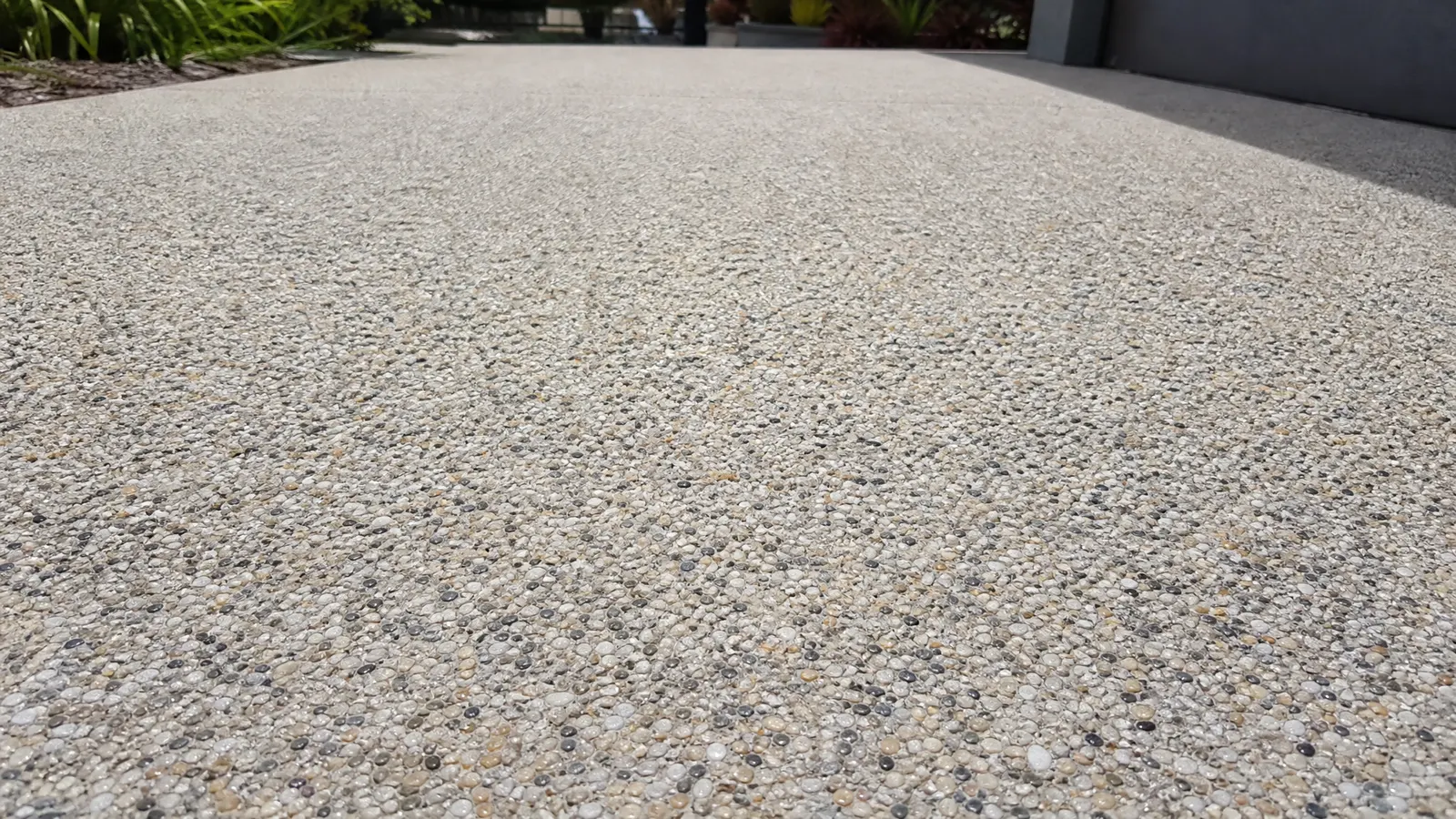 Close-up of clean well-maintained exposed aggregate surface showing natural stone detail and sealed finish on Gold Coast home