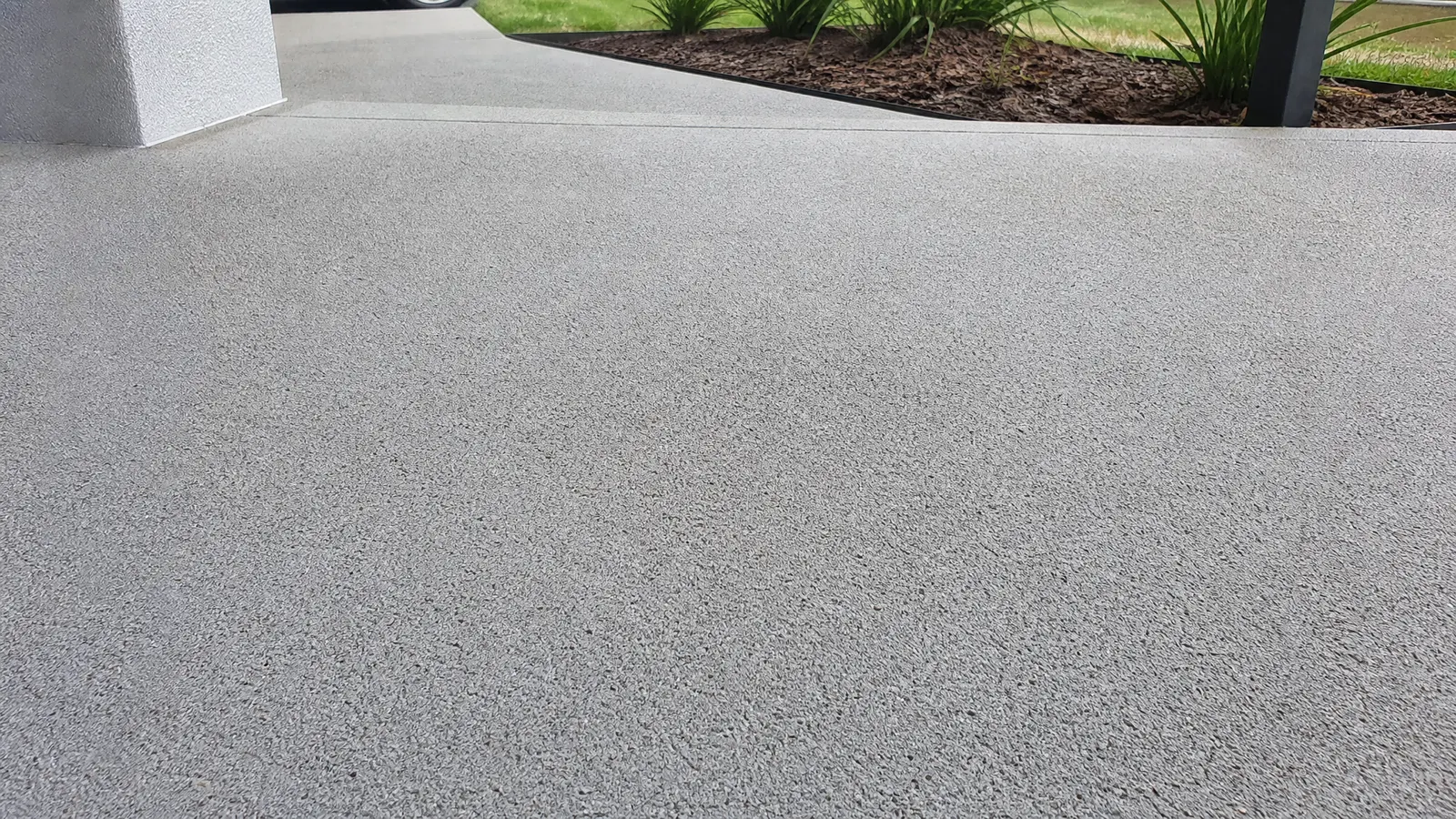 Close-up comparison of non-slip treated concrete surface versus smooth untreated surface showing texture difference for pool areas