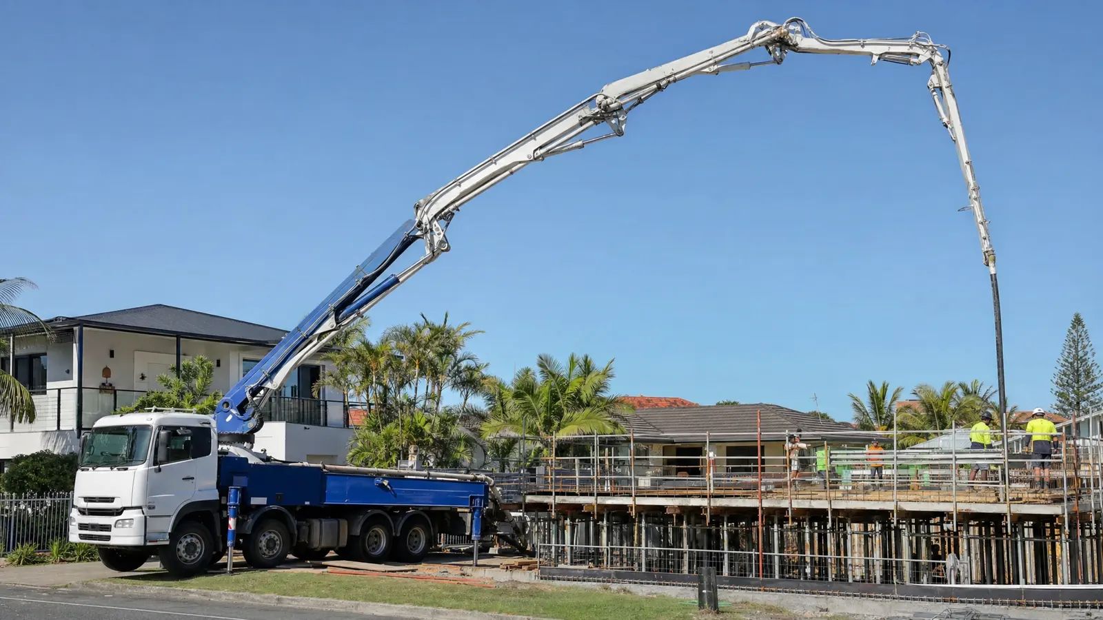 Concrete pump truck with extended boom delivering concrete to a residential slab pour on a Gold Coast construction site