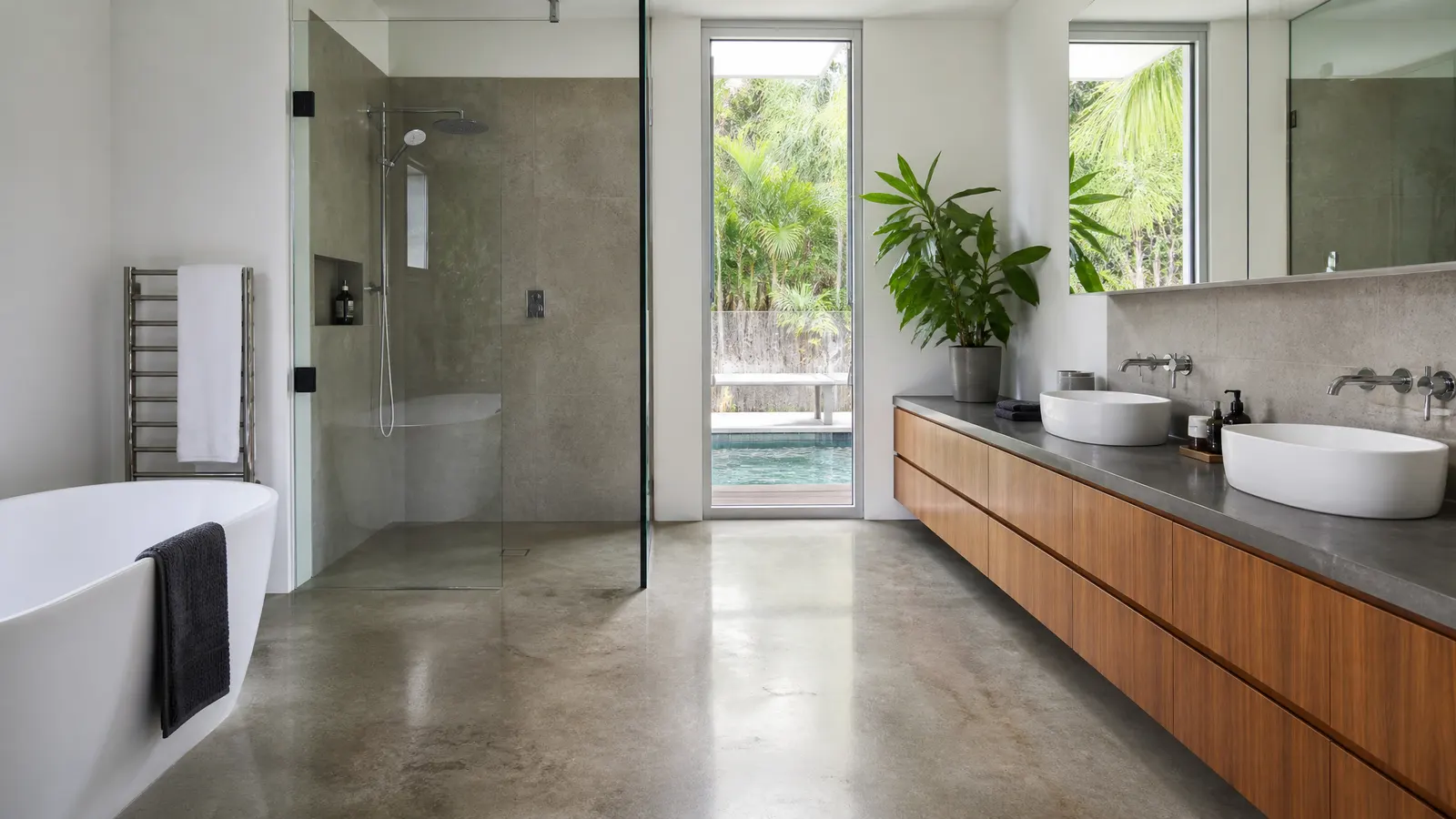 Modern Gold Coast bathroom with polished concrete floor showing warm tones and seamless transition to outdoor area